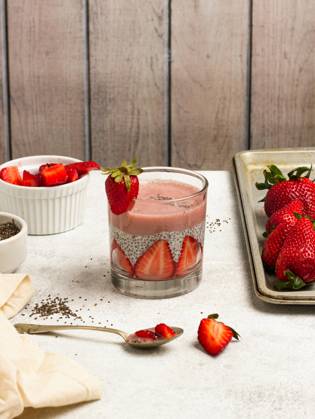 Tasty pudding with chia seeds and slices of fresh strawberries placed on table near ingredients for healthy breakfast NadiaSapollnik_ChiaFruit_3.jpg Copyright: xNadiaxSapollnikx Model Released