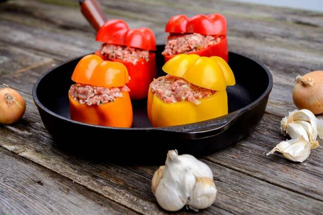  colorful filled pepper,garlic and onion in iron pan, 25.09.2021, Copyright: xarnoaltixx Panthermedia23513394