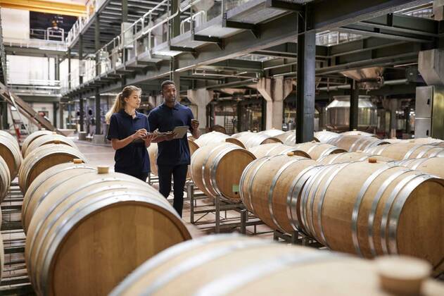 IMAGO Creative: Business, Inflation und Lieferketten Two staff inspecting barrels in a wine factory warehouse model released, Symbolfoto, 27.09.2021, Copyright: xMonkeybusinessx Panthermedia24750792