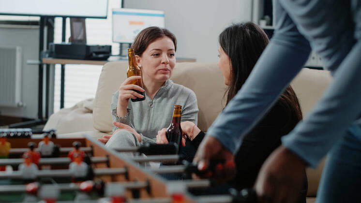 Close up of women with bottles of beer and snacks talking Close up of women with bottles of beer and snacks talking at office after work. Colleagues enjoying free time with alcoholic beverage to do fun activity with entertainment after hours Copyright: xx 43945936