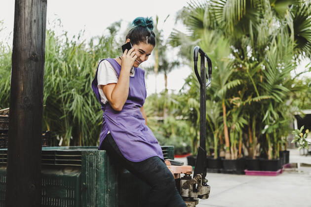 IMAGO Creative: Business, Innovative Technologie-Lösungen Happy female owner talking on smart phone in garden center Spain, Andalucia, model released, property released Copyright: xMaskotx , MA91533