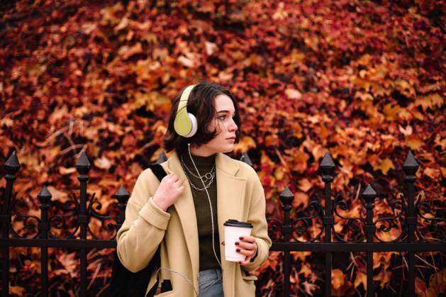 IMAGO Creative, Jahreszeit Herbst, Ferien IMAGO Creative: Ende des Sommers Young woman listening music in headphones standing in city in autumn CR_DMBE220203-885866-01 ,model released, Symbolfoto
