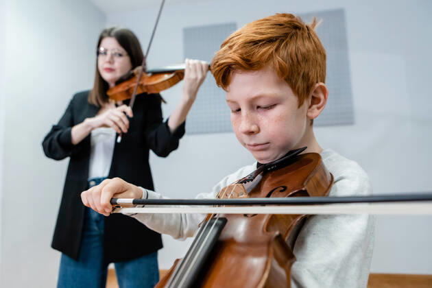 IMAGO Creative: Bildung, Musikerziehung Female teacher and boy playing violins during lesson in modern music school, Model released, Property released OlgaGuardon_MusicSchool_23.jpg Copyright: xOlgaxGuardonx MR