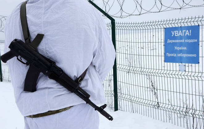 Ukraine Konflikt, Historie KHARKIV REGION, UKRAINE - FEBRUARY 16, 2022 - An armed border guard in a snow camouflage uniform stands before a fence at the Ukraine-Russia border, Kharkiv Region, northeastern Ukraine. Ukraine-Russia border in Kharkiv Region  Copyright: xVyacheslavxMadiyevskyyx