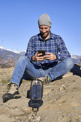 IMAGO Creative: Business, Innovative Technologie-Lösungen Smiling man text messaging through smart phone sitting on rock model released, VEGF05327