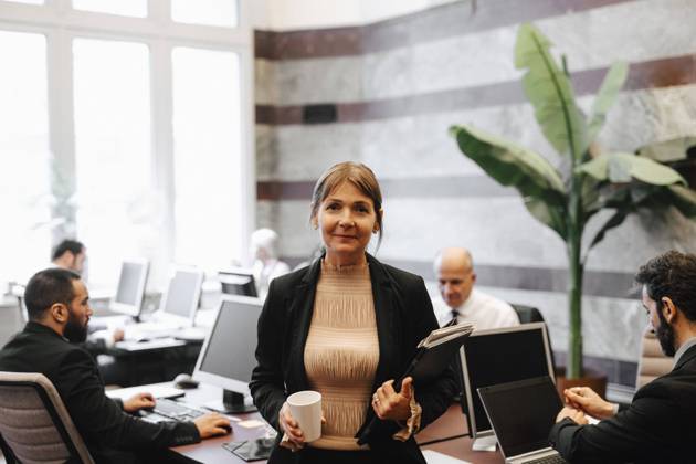 IMAGO Creative: Business, Innovative Technologie-Lösungen Portrait of smiling mature female leader holding coffee cup and documents at law office Sweden, Stockholm, model released, property released Copyright: xMaskotx , MA92500