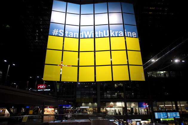 Ukraine, Refugees DEU, Deutschland, Germany, Berlin, 22.03.2022 Grossplakat StandWithUkraine Stand With Ukraine. Ankunft von Fluechtlingen aus der Ukraine am Hauptbahnhof Berlin, Deutschland. Die Fluechtlinge zumeist Frauen und Kinder fliehen vor dem Krieg in der Ukraine nach der Invasion von Russland und erhalten Unterstuetzung von Freiwilligen. Zehntausende Flüchtlinge, die nach der russischen Militaerinvasion vor dem anhaltenden Krieg in der Ukraine geflohen sind, sind in den letzten Wochen hauptsaechlich mit Zuegen ueber Polen angekommen. en: Poster StandWithUkraine Stand With Ukraine. Ukrainian refugees disembark a train From Poland after arriving at the main railway station Hauptbahnhof in Berlin, Germany. Tens of thousands of refu