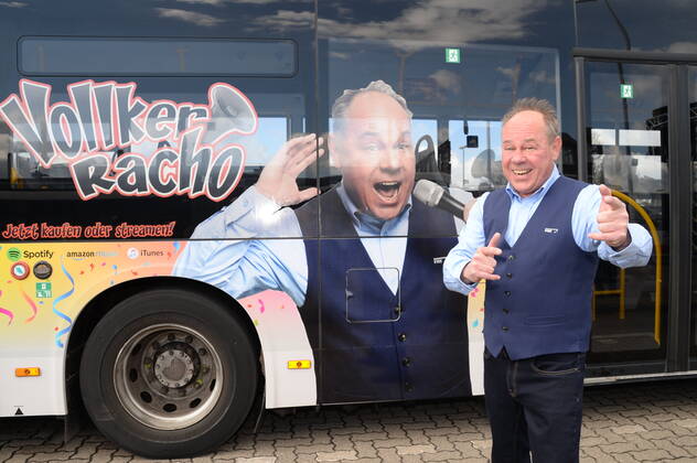Vollker Racho, bürgerlich Rodney Greie, stellt seinen neuen Busfahrer-Song: Ich fahr ˜nen Linienbus auf dem VHH-Betriebshof in Schenefeld vor. Vollker Racho, 50, stand 16 Jahre lang mit Hits wie mit Partyhits wie Das rote Pferd oder Eine Insel mit zwei Bergen in Clubs, Diskotheken und Bars in ,Deutschland und auf Mallorca, auf der Bühne. Aufgrund der Corona-Pandemie und den damit verbundenen Einschränkungen im Eventbereich hatte sich der zweifache Familienvater Rodney Greie vor gut zwei Jahren umorientiert. Er sagte der Partybühne zumindest vorübergehend Lebewohl und machte eine Ausbildung zum Busfahrer. Seither ist Ro..dney Greie bei der VHH im Fahrdienst tätig. Hamburg, der 08.04.2022 Von der Partybühne ans Le