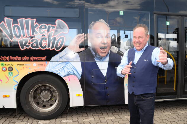 Vollker Racho, bürgerlich Rodney Greie, stellt seinen neuen Busfahrer-Song: Ich fahr ˜nen Linienbus auf dem VHH-Betriebshof in Schenefeld vor. Vollker Racho, 50, stand 16 Jahre lang mit Hits wie mit Partyhits wie Das rote Pferd oder Eine Insel mit zwei Bergen in Clubs, Diskotheken und Bars in ,Deutschland und auf Mallorca, auf der Bühne. Aufgrund der Corona-Pandemie und den damit verbundenen Einschränkungen im Eventbereich hatte sich der zweifache Familienvater Rodney Greie vor gut zwei Jahren umorientiert. Er sagte der Partybühne zumindest vorübergehend Lebewohl und machte eine Ausbildung zum Busfahrer. Seither ist Ro..dney Greie bei der VHH im Fahrdienst tätig. Hamburg, der 08.04.2022 Von der Partybühne ans Le