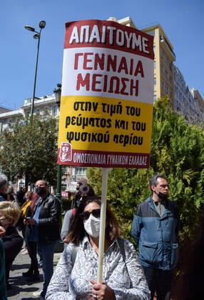 Greece: Thousands take to Athens streets in protest of price hikes A woman demonstrates against price hikes holding banner that reads: We demand decrease in electricity and natural gas prices Athens Greece Copyright: DimitrisxAspiotis