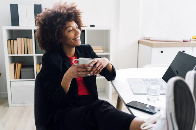 IMAGO Creative: 2022 Favoriten IMAGO Creative: Business - Work-Life Balance Smiling businesswoman sitting at desk with coffee cup in office model released, Symbolfoto property released, GIOF15178