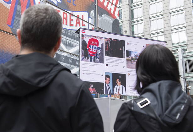 April 23, 2022, Montreal, PQ, Canada: People look up at a screen displaying messages of condolences and memories for Montreal Canadiens legend Guy Lafleur outside the Bell Centre in Montreal, Saturday, April 23, 2022. Lafleur passed away Friday at the age of 70. Montreal Canada - ZUMAc35_ 20220423_zaf_c35_018 Copyright: xGrahamxHughesx