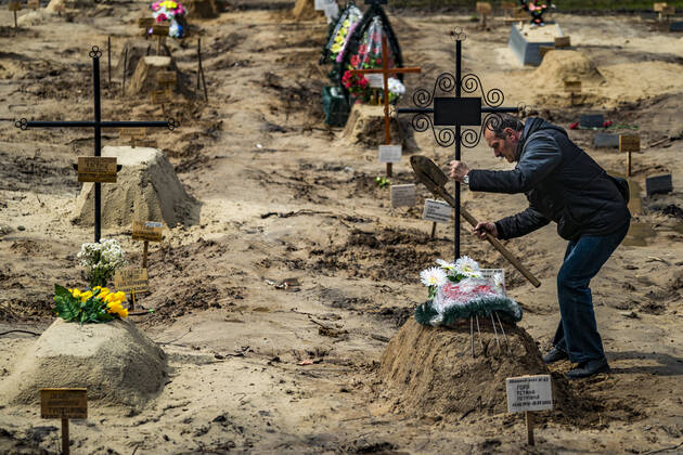 News Bilder des Tages April 26, 2022, Chernihiv, Chernihiv, Ukraine: A man holds a cross after burying a relative killed during the occupation of the russian army in Chernihiv. Corpses have to wait until their final destination in a cementery, and usually are buried by a relative. Chernihiv Ukraine - ZUMAa131 20220426_zap_a131_014 Copyright: xCelestinoxArcexLavinx