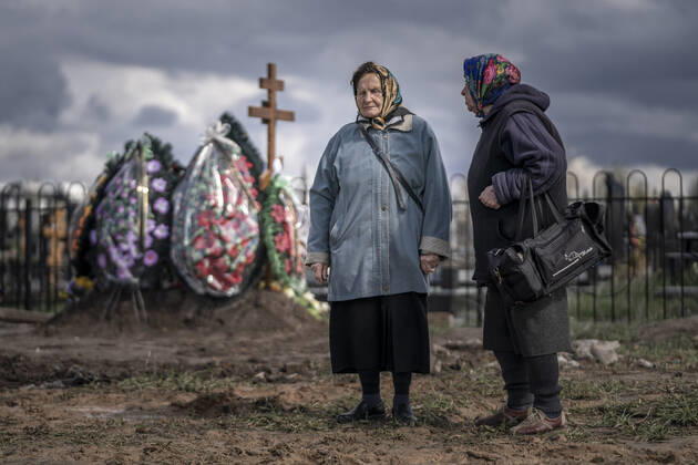 Two women who sing as part of burial ceremonies prepare to sing traditional songs for yet another of many burials at a cemetery in Borodyanka, Ukraine on Tuesday, April 26, 2022. U.S. Secretary of State Antony Blinken told Congress on Tuesday that the Biden administration hasn t seen any evidence that Russian President Vladimir Putin plans to end the war in Ukraine through diplomatic efforts.  KYV22020426526 KenxCedeno