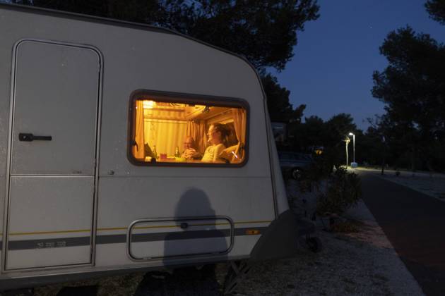 Man and woman sitting in caravan at night Seget Vranjica Croatia Copyright: xUtexGrabowsky photothek.dex