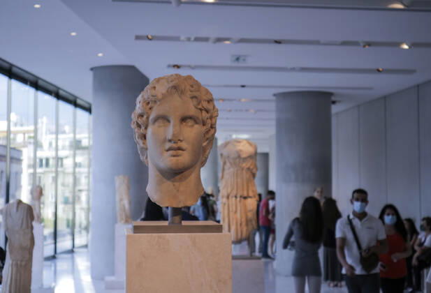 Tourists and locals visit the Acropolis Museum in Athens during International Museum Day Visistors pass by the head of a statue of Alexander the Great in the Acropolis Museum. Tourists and locals visit the Acropolis Museum in Athens and enjoy free entrance as part of the celebrations on International Museum Day. Athens Greece Copyright: DimitrisxAspiotis