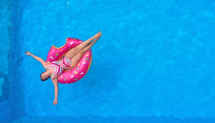 15 06 2022, The own swimming pool in the garden provides refreshment in the summer in the next days of June heat wave Aerial view of a garden pool in Unterallgäu teenager sunbathing on a swimming tire in the water Modelreleased 15 06 2022, Swimming pool in your own garden 15 06 2022, Swimming pool in your own garden