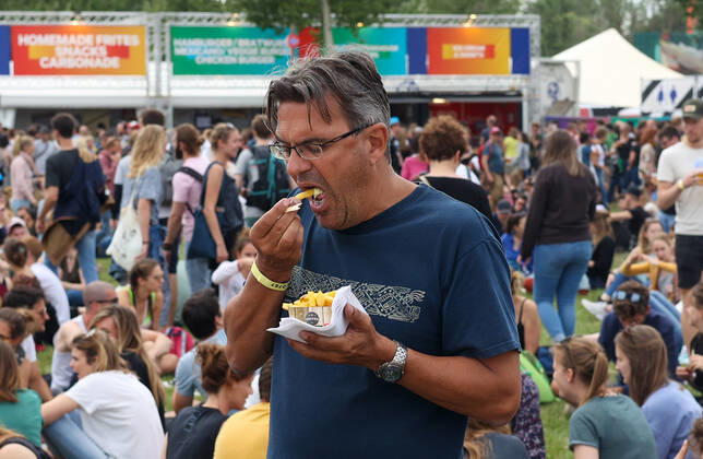 Illustration picture shows a festival goer with a packet of frites (frietjes, frieten, fries) at the one-day Werchter Boutique festival, in Werchter, on Friday 18 June 2021.  VIRGINIExLEFOUR 36482082