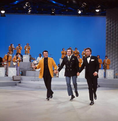 DREI MAL NEUN Drei mal Neun, ZDF Quizshow, Deutschland, 1971, im Bild: Bandleader Max Greger mit Bigband, Showmaster Wim Thoelke und Showgast Peter Alexander bei einer heiteren Showdarbietung. Drei mal Neun, TV quiz show, Germany, 1971, on the photo: Bandleader Max Greger with Big band, presenter Wim Thoelke and show guest Peter Alexander with a cheerful show performance., Deutschland Copyright: ArthurxGrimm UnitedArchives82007884 EDITORIAL USE ONLY