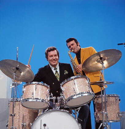 DREI MAL NEUN Drei mal Neun, ZDF Quizshow, Deutschland, 1971, im Bild: Showmaster Wim Thoelke, hier am Schlagzeug mit Bandleader Max Greger am Saxophon. Drei mal Neun, TV quiz show, Germany, 1971, on the photo: presenter Wim Thoelke, here on the drums with Band leader Max Greger on saxophone., Deutschland Copyright: ArthurxGrimm UnitedArchives82007921 EDITORIAL USE ONLY