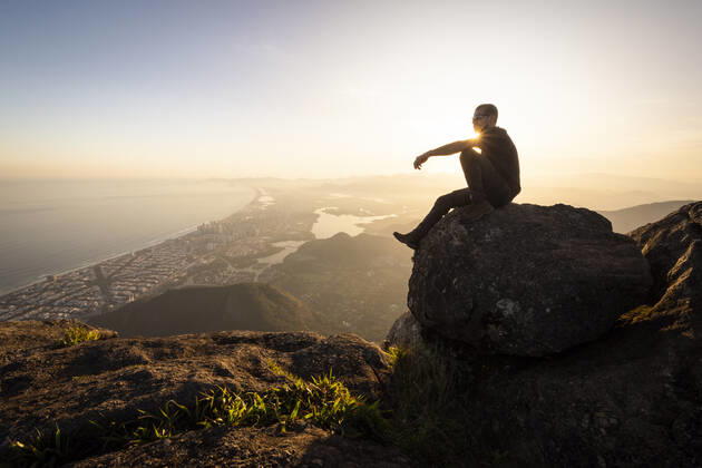Man enjoying beautiful sunset view to city from rocky mountain top Rio de Janeiro, State of Rio de Janeiro, Brazil CR_GNUJ22070662-1004290-01 ,model released, Symbolfoto