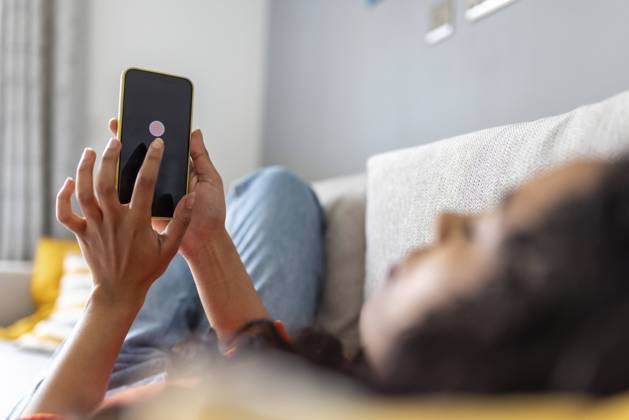 IMAGO Creative, Lifestyle, Tik Tok-Trend thatgirl IMAGO Creative: Business, Innovative Technologie-Lösungen Woman turning off mobile phone using smart phone in living room model released, Symbolfoto property released, WPEF06007