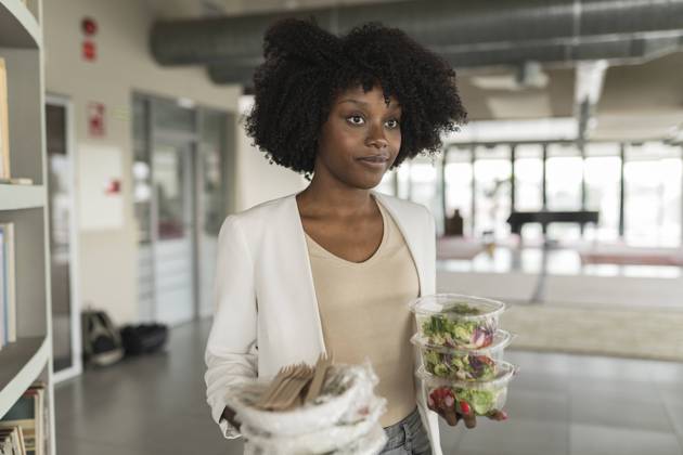 Young businesswoman with salad boxes standing in office model released, Symbolfoto property released, JCICF00173