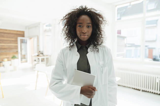 IMAGO Creative: Business, Innovative Technologie-Lösungen Female doctor with curly hair holding tablet PC model released, Symbolfoto property released, KNSF09407