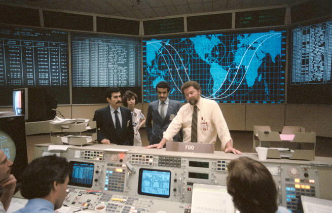 S85-29711 (April 1985) --- Ronald C. Epps, right of the training division in the mission operations directorate, briefs the Saudi Arabian payload specialist, Sultan Salman Abdelazize Al-Saud, and his backup, Abdulmohsen Hamad Al-Bassam, in the flight control room (FCR) of the mission control center (MCC). Erlinda Stevenson is also pictured. Copyright: xpiemagsx piemagsspace-2523 !ACHTUNG AUFNAHMEDATUM GESCHÄTZT!