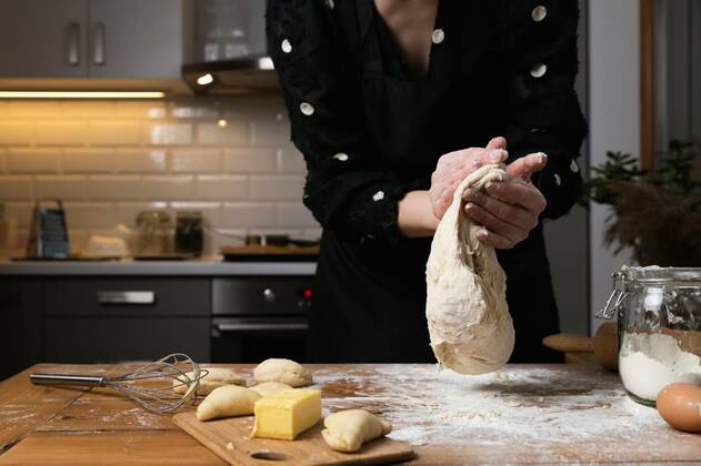  Young beautiful woman kneading dough at a wooden table in kitchen. Housewife hobbies concept., Young beautiful woman kneading dough at a wooden table in kitchen. Housewife hobbies concept. model released, Symbolfoto , 06.12.2020, Copyright: xartursfotox Panthermedia29081319.jpg