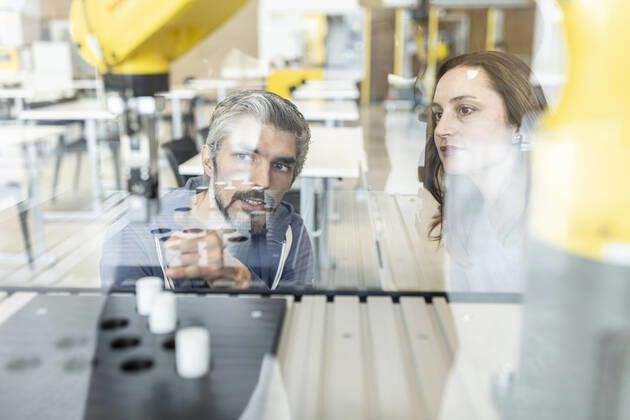 IMAGO Creative: Business, Inflation und Lieferketten Engineers testing industrial robot in glass cabin model released, Symbolfoto property released, WESTF24846