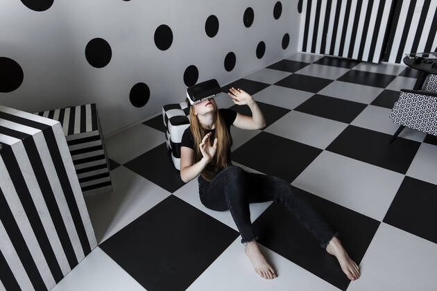 IMAGO Creative: Business, Innovative Technologie-Lösungen Girl wearing virtual reality headset sitting on checkered floor model released, Symbolfoto property released, LLUF00810