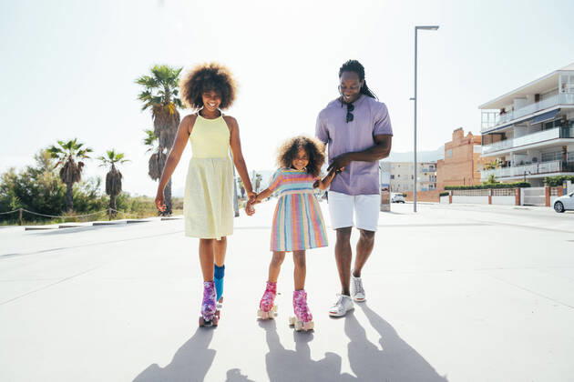 Smiling daughters roller skating with father on sunny day model released, Symbolfoto, OIPF02192