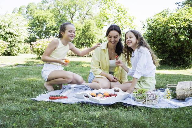 Happy daughters having picnic with mother at park on weekend model released, Symbolfoto, OSF00500