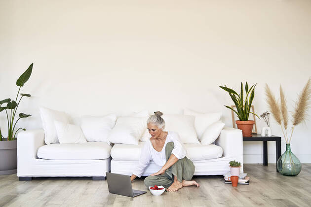 IMAGO Creative: Business, Innovative Technologie-Lösungen Woman using laptop sitting on floor in living room model released, Symbolfoto property released, VEGF05801