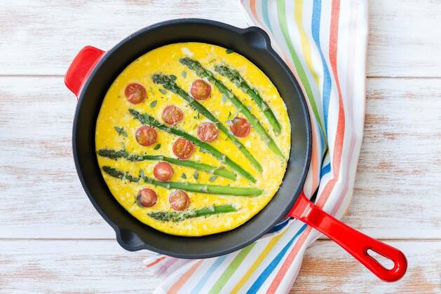  Frittata with fresh asparagus and cherry tomatoes. Top view, Top view of freshly made frittata with green asparagus and cherry tomatoes in a frying pan, Top view of freshly made frittata with green asparagus and cherry tomatoes in a frying pan, 22.04.2021, Copyright: xStockPhotoAdviserx Panthermedia29833545.jpg