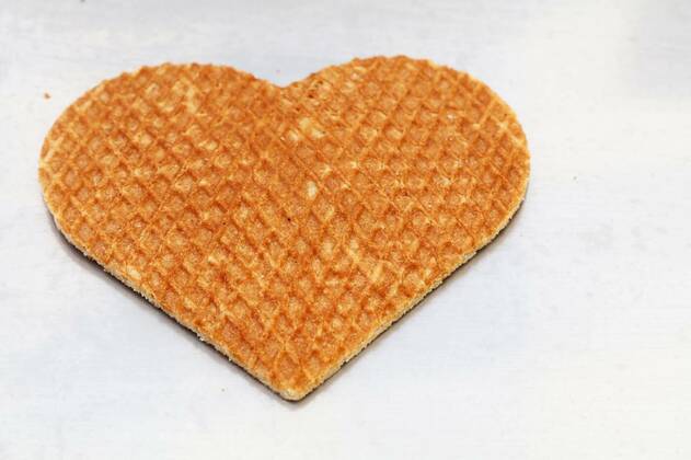  Heart shaped Dutch stroopwafel waffle on white, Close up one heart shaped traditional sweet Dutch stroopwafel (syrup waffle) cookie on white baking paper, high angle view, Close up one heart shaped traditional sweet Dutch stroopwafel (syrup waffle) cookie on white baking paper, high angle view, 28.01.2022, Copyright: xBreakingTheWallsx Panthermedia31084962.jpg