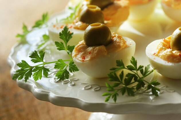  Spicy deviled eggs garnished with green olives, Spicy deviled eggs garnished with green olives ., Spicy deviled eggs garnished with green olives ., 07.02.2022, Copyright: xVaivirgax Panthermedia31114667.jpg