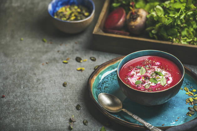 Spring detox beetroot soup with mint, chia, flax and pumpkin seeds in blue ceramic bowl over grey concrete background Spring detox beetroot soup with mint, chia, flax and pumpkin seeds in blue ceramic bowl over grey concrete background, copy space. Dieting, clean eating, vegan, vegetarian, weight loss food concept Copyright: xAnnaxIvanovax AI140217-30