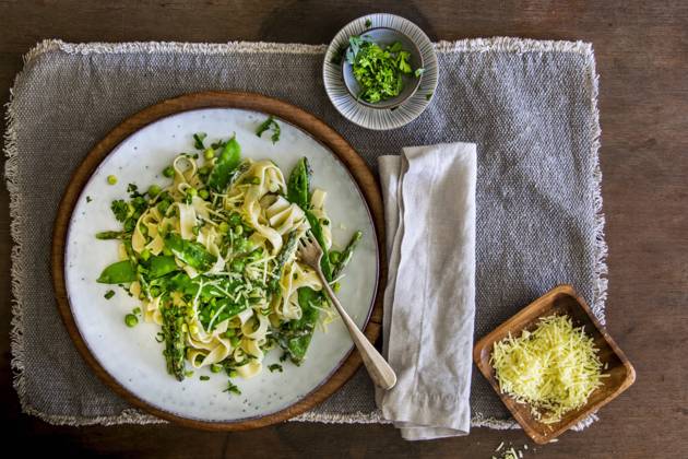 Freshly made Pasta Primavera with green asparagus, peas and sugar snaps on stoneware plate over wooden background with copy space Copyright: xClaudiaxHirschberger,xArnexSchmidtx KAS130519-30