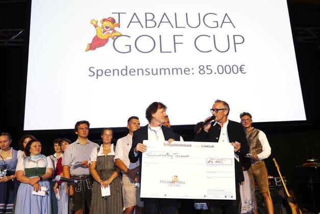 28 Tabaluga Golf Cup Michael Roll and his wife Claudia present the head of the Tabaluga Foundation Dr Jürgen Haerlin with a donation check for 90 000 Euro, Tutzing Bavaria Germany Golf Course Tutzing