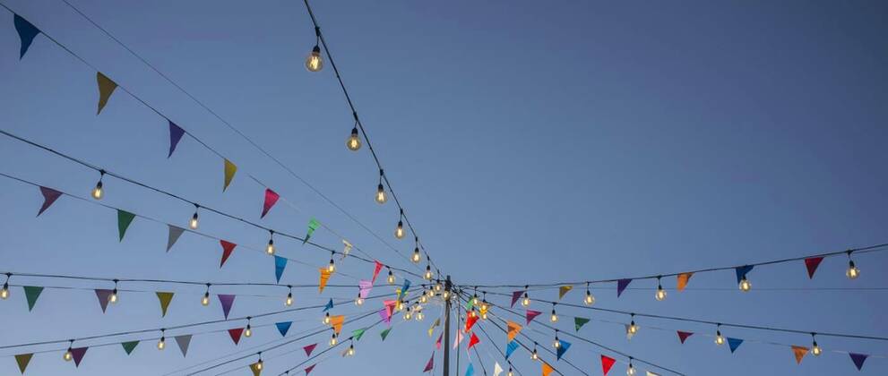  Garland with colorful pennants and light bulbs on pole over blue sky, Garland with colorful pennants and light bulbs on pole over blue sky. Long format, Garland with colorful pennants and light bulbs on pole over blue sky. Long format, 11.10.2021, Copyright: xWHPicsx Panthermedia30792059.jpg