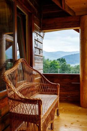  Terrace with wicker bench on wooden balcony with mountain views., Beautiful outdoor terrace with wicker bench on wooden balcony with mountain views. Wicker products. Decor elements of a wooden cottage for relaxing in the mountains., Beautiful outdoor terrace with wicker bench on wooden balcony with mountain views. Wicker products. Decor elements of a wooden cottage for relaxing in the mountains., 30.05.2022, Copyright: xserkucherx Panthermedia31460241.jpg