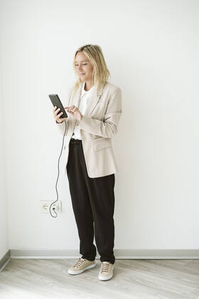 Businesswoman using mobile phone while charging model released, Symbolfoto property released, EBBF06259