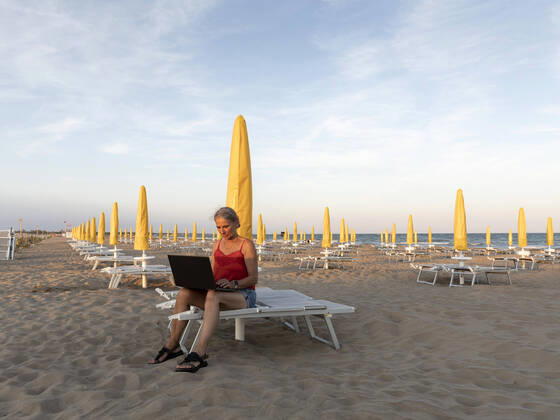 IMAGO Creative: Business - Work-Life Balance Senior businesswoman using laptop at beach model released, Symbolfoto, FLLF00673