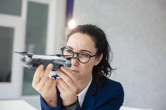 IMAGO Creative: Business, Innovative Technologie-Lösungen Businesswoman with eyeglasses looking at drone model released, Symbolfoto property released, JOSEF11977
