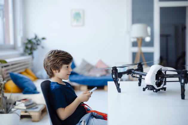 IMAGO Creative: Business, Innovative Technologie-Lösungen Boy playing with drone on table at home model released, Symbolfoto property released, JOSEF12151