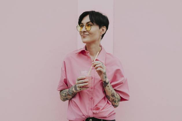 Smiling woman wearing eyeglasses holding glass standing in front of wall model released, Symbolfoto property released, OIPF02340