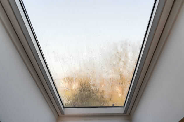 Germany, Bavaria - 31 October 2022: Fogged skylight in the morning. Water drops from condensation on a window