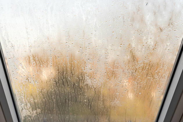 Germany, Bavaria - 31 October 2022: Fogged skylight in the morning. Water drops from condensation on a window